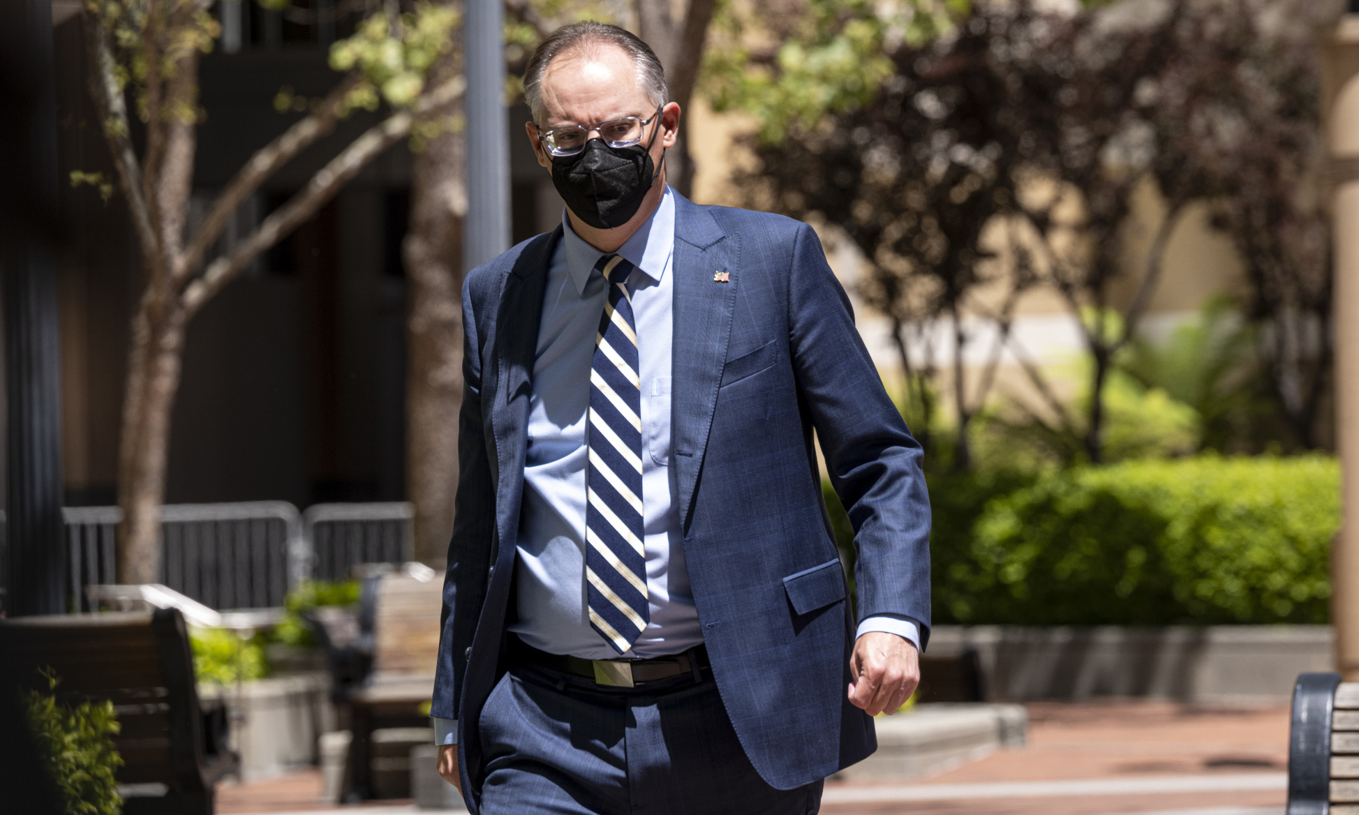 Tim Sweeney wearing a suit and cloth facemask, walking outside the US district courthouse in Oakland on the first day of the Epic v Apple trial.