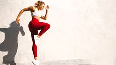 a woman jumping in a pair of red gym leggings