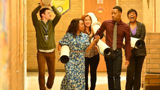 Chris Perfetti as Jacob Hill, Quinta Brunson as Janine Teagues, Lisa Ann Walter as Melissa Schemmenti, Tyler James Williams as Gregory Eddie, and Sheryl Lee Ralph as Barbara Howard carry rolled up carpets in Abbott Elementary