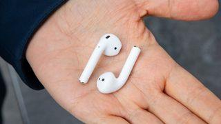 Apple AirPods i en håndflate.