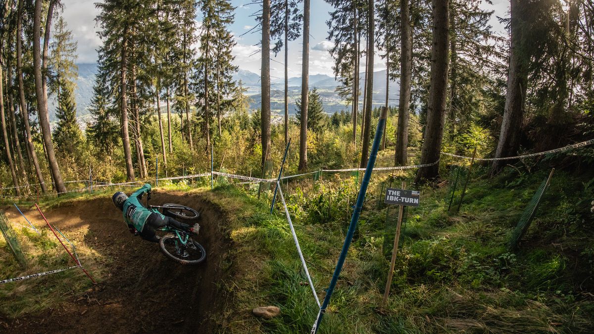 A downhill rider rounds a berm