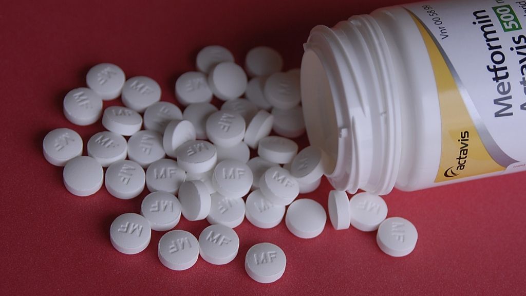 metformin tablets spilling out of a pill bottle onto a table