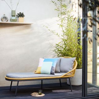 Garden lounger with cushions and planted bamboo