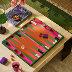 Addison Ross lacquer backgammon set on a low coffee table with a green wireless lamp and a matching rug underneath