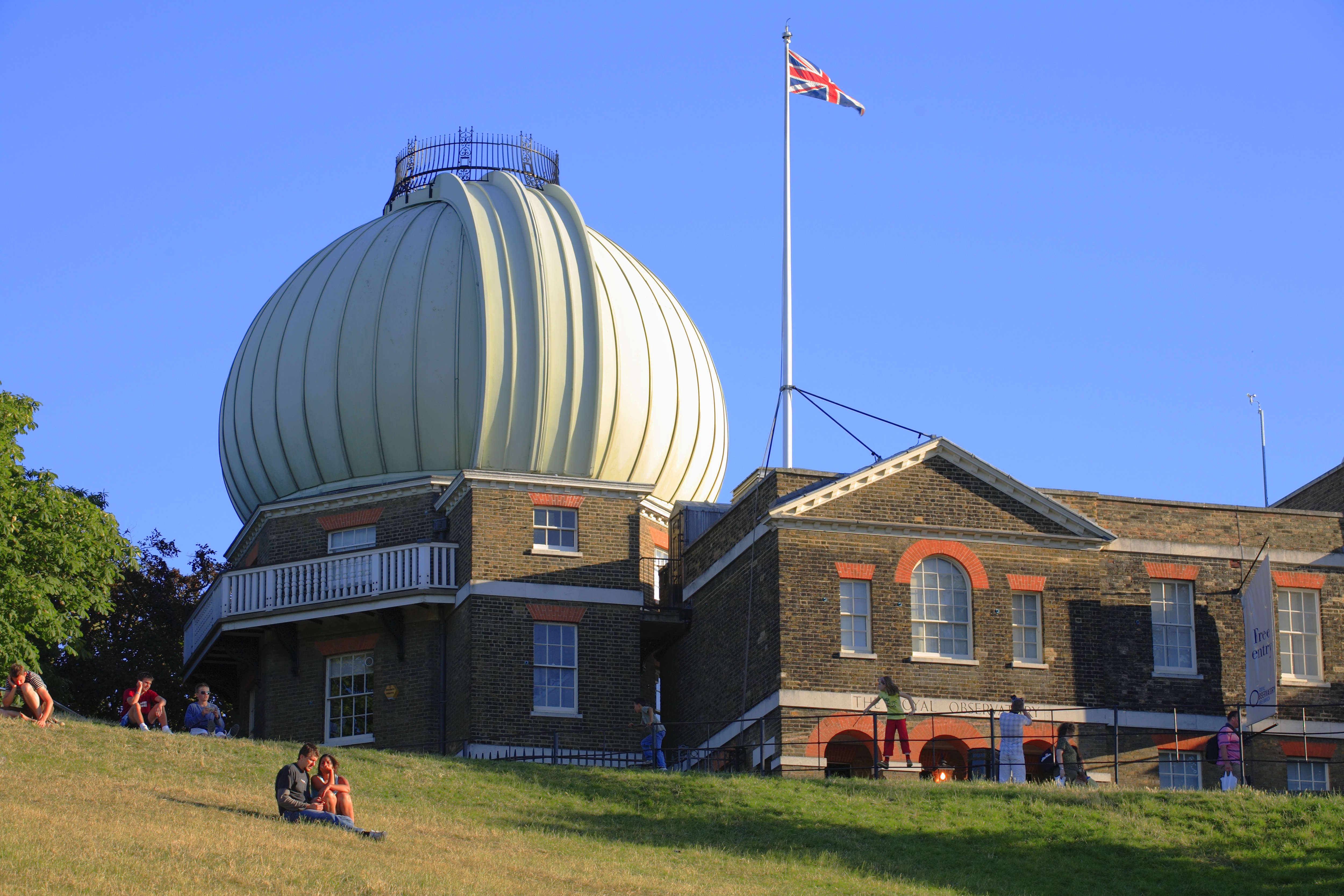 A building with a large metal dome sits on a heavy hill