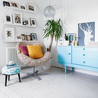 White floor boards with white walls and blue sideboard