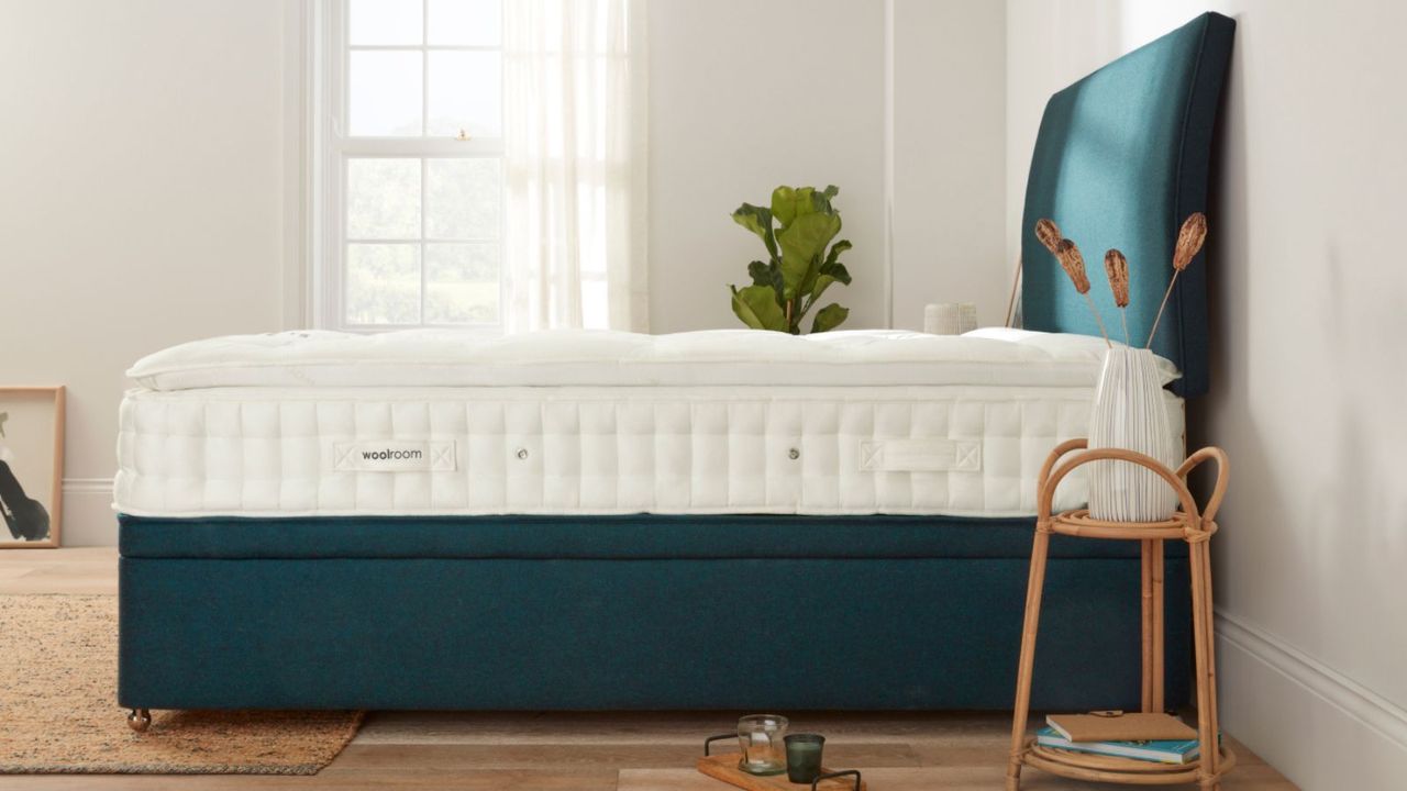 Side view of a Woolroom mattress against a white wall.