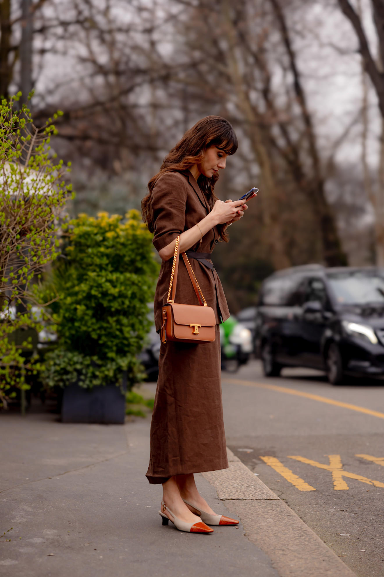 Woman in two-tone cap toe shoes and a brown dress