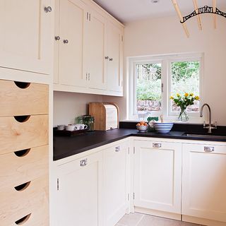 kitchen area with wooden units and black worktop