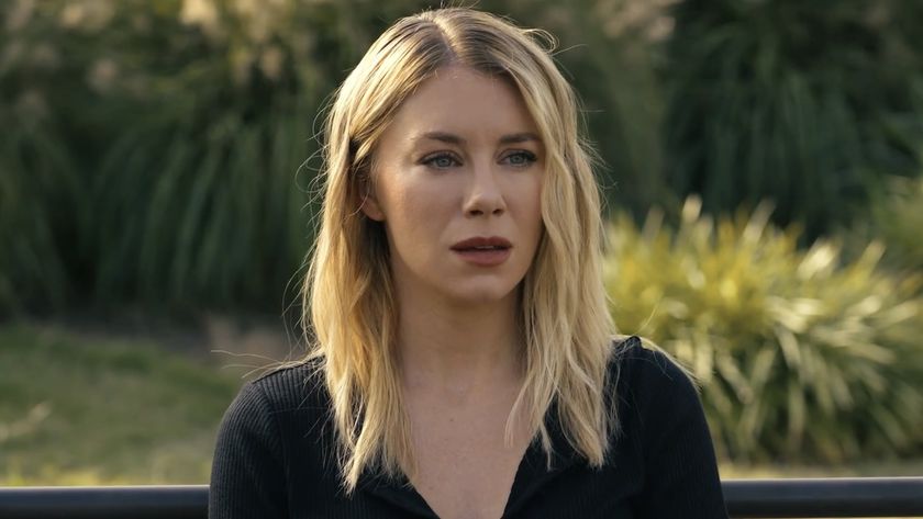 Jennifer Holland as Emilia Harcourt sitting on park bench in Peacemaker Season 2