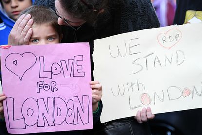 People hold signs supporting London.