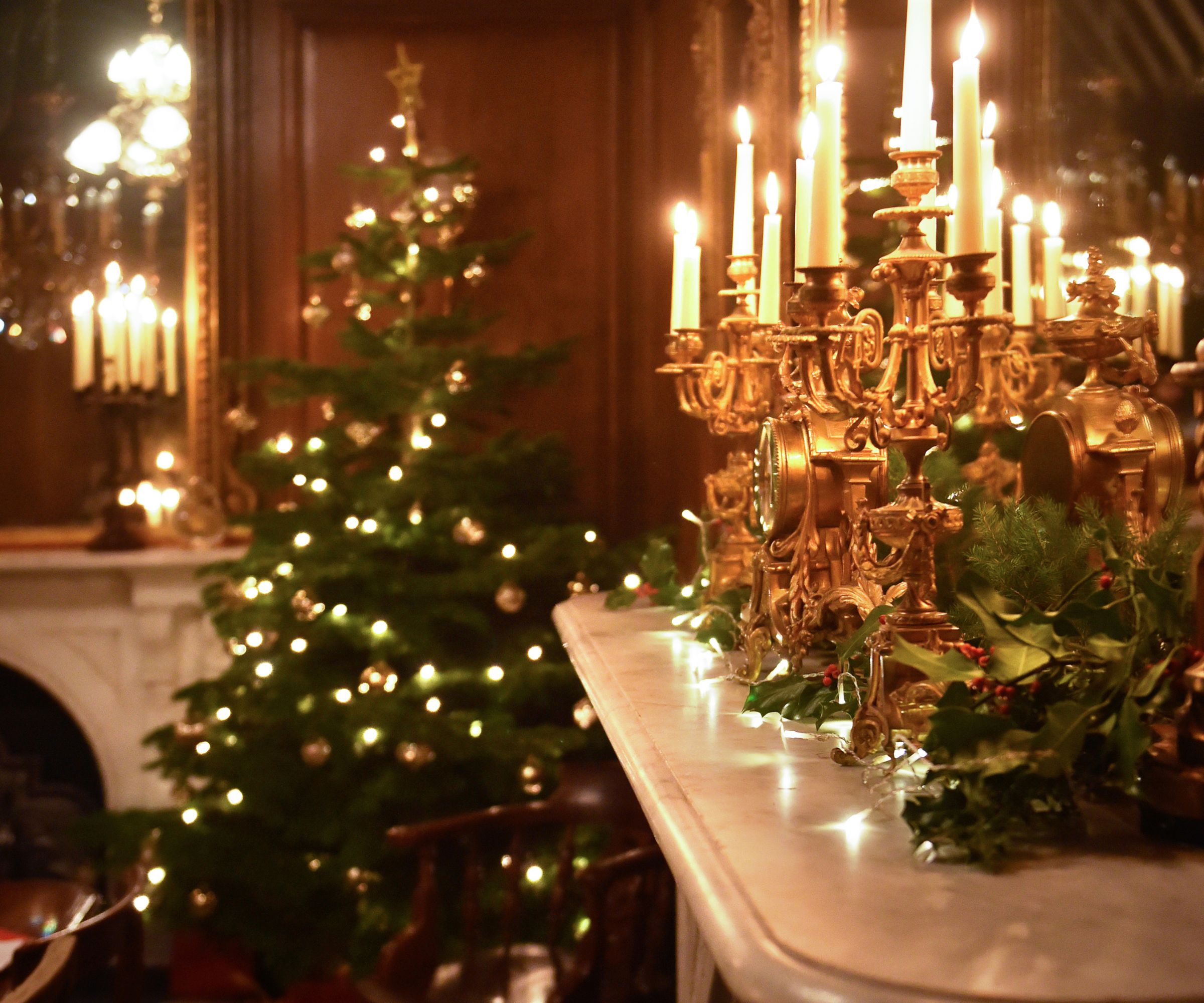 Marble mantel with gold candelabras and Christmas tree in background