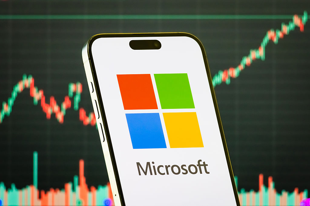 smartphone displays the logo of Microsoft Corporation (NASDAQ: MSFT), one of the world's largest technology companies, in front of a screen showing the company's latest stock market chart on July 28