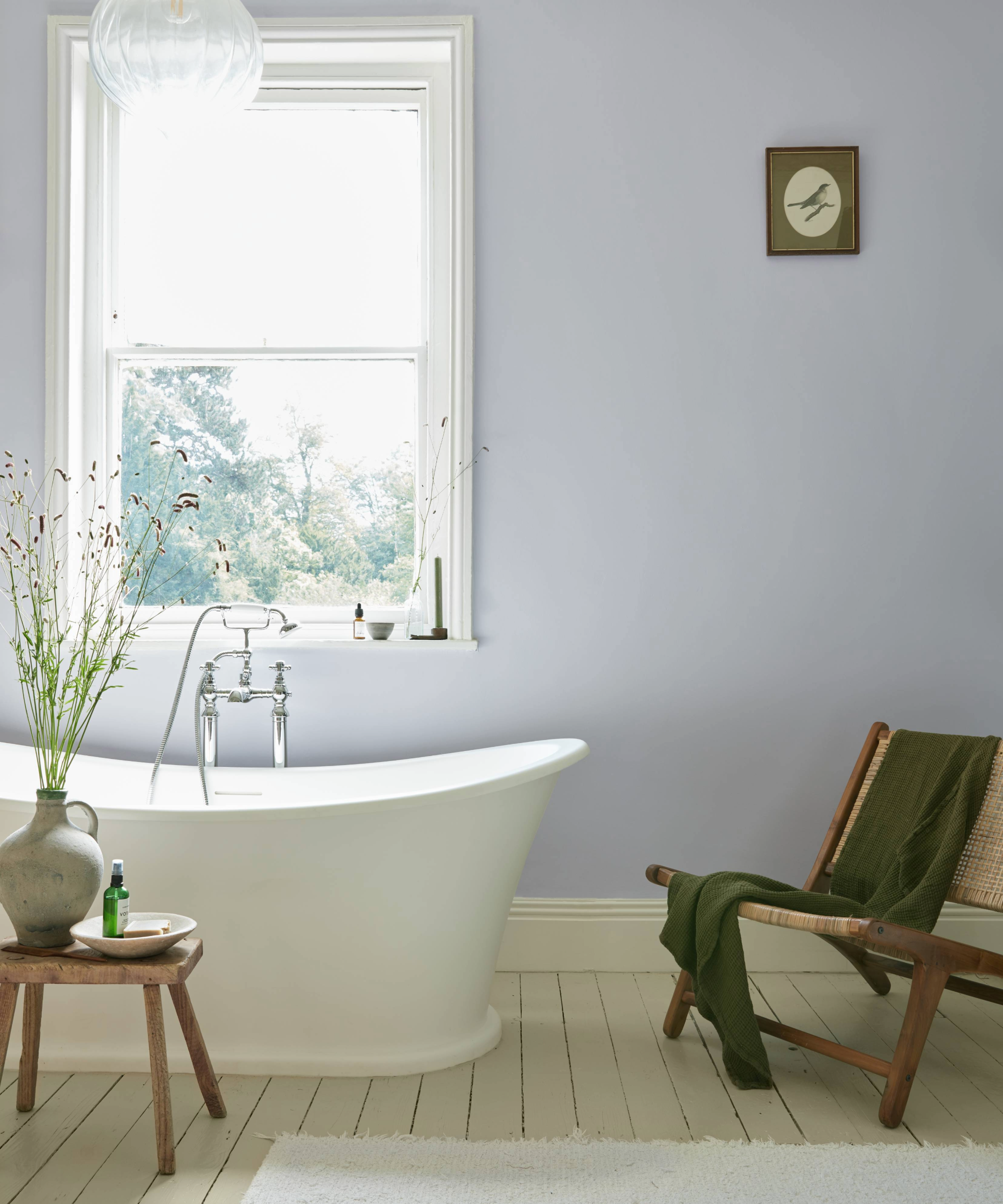 Freestanding bath next to a window, chair and mini table