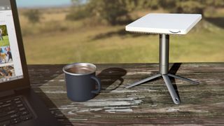 a small internet antenna next to a cup of coffee on an outdoor table