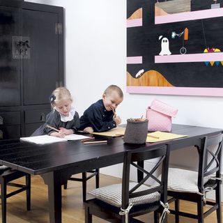 childrens playroom with black cupboard and black table chair