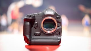 Canon EOS R1 sat on the court in front of a game of basketball