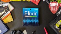 A pack of Elixir electric guitar strings on a desk with lots of other string packs surrounding it