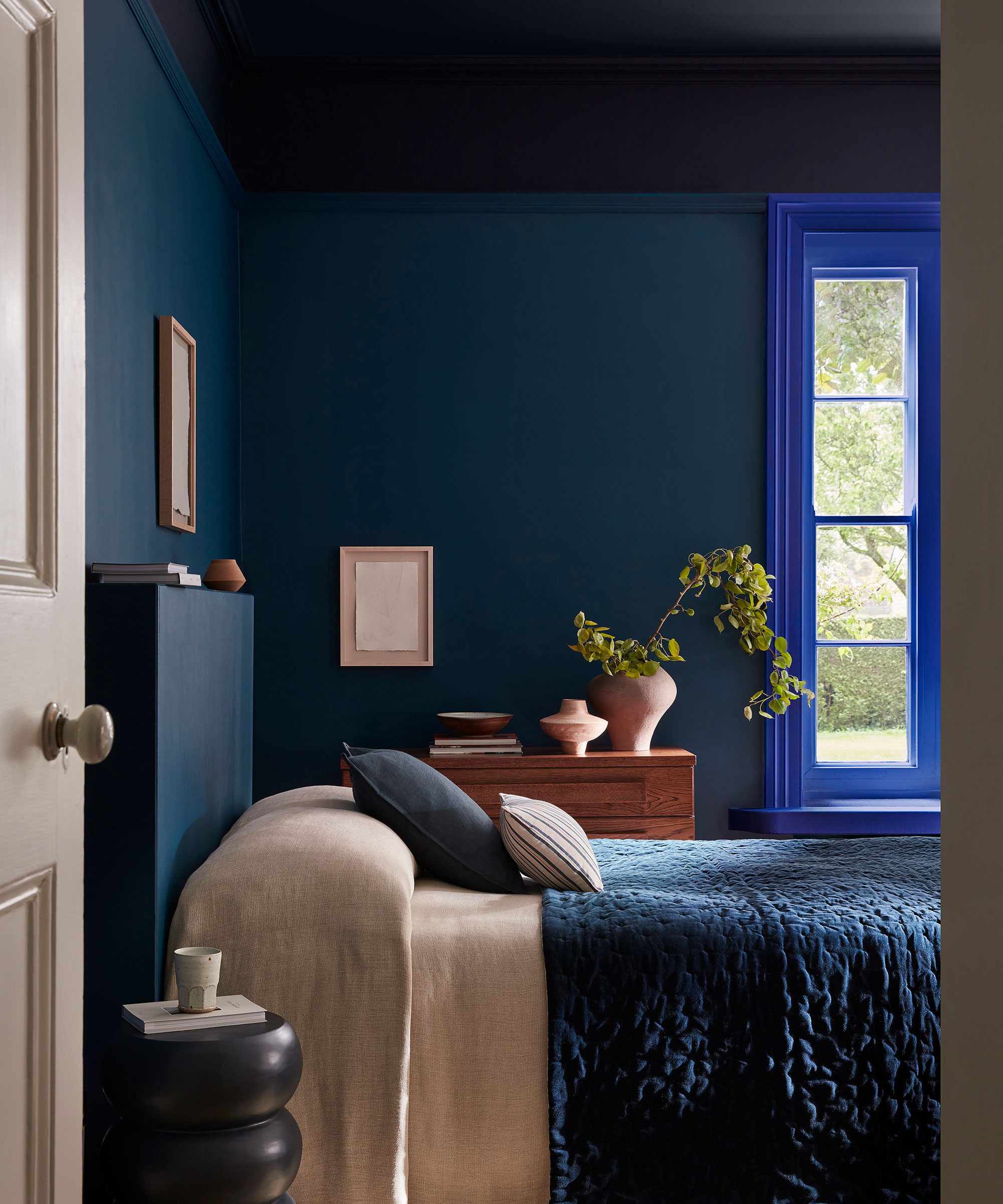 dark blue bedroom with bright blue window