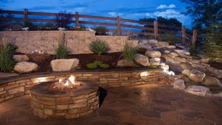 A patio with a fire pit, plus seating and lighting within the bricks