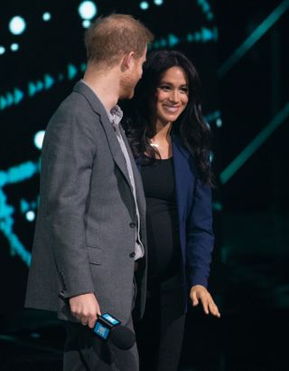 Meghan Markle wears a navy blazer onstage with Prince Harry