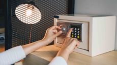 Hands inputting code to small home safe