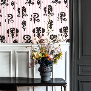 room with pink wallpaper trees flowerpots
