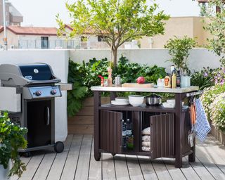 An external cooking area with barbecue and wheeled outdoor kitchen furniture