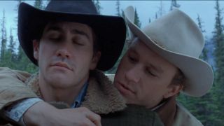 From left to right: Jack closing his eyes while Ennis stands behind him putting his left arm around Jack. 