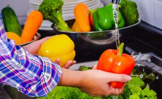 Washing vegetables in a sink.