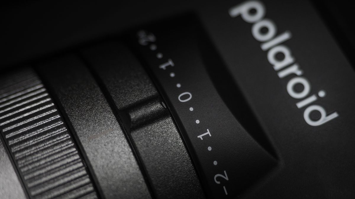 Polaroid I-2 camera on a wooden surface with dramatic lighting