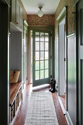 Small entryway with green woodwork and wallpaper
