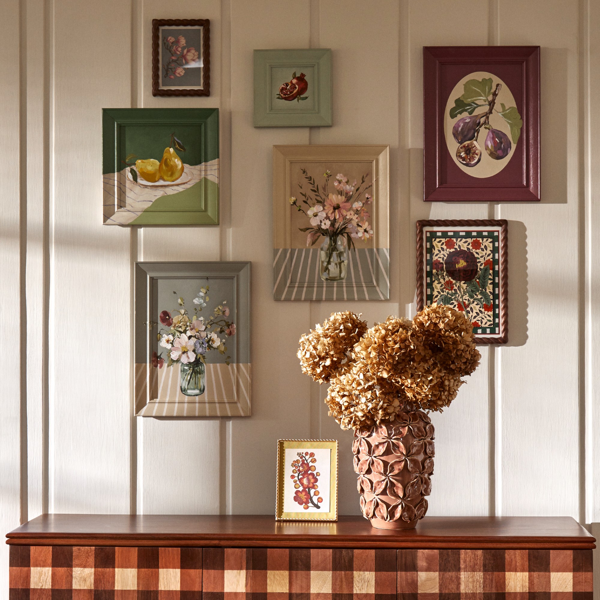 Dunelm Posie gingham sideboard against a panelled wall with a vase of dried hydrangeas on top and framed wall art above it