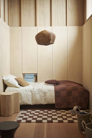 An all wood kids bedroom full of natural materials and detailed bedding