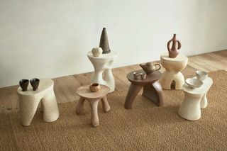 Various vessels on sculptural low stools