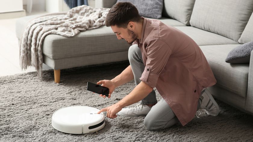 Man setting robot vacuum on rug