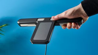 a close up of the pull out handle of a body fat smart scale by renpho with a pull out handle to measure limb fat percentage and silver electrodes and a blue and black casing rests on a surface in front of a blue background