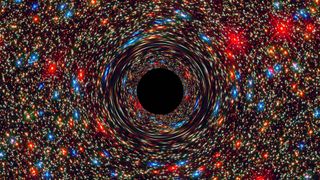 This computer-simulated image shows a supermassive black hole at the core of a galaxy. The black region in the center represents the black hole’s event horizon, where no light can escape the massive object’s gravitational grip. The black hole’s powerful gravity distorts space around it like a funhouse mirror. Light from background stars is stretched and smeared as the stars skim by the black hole.