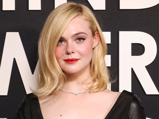 Elle Fanning smiles at the camera wearing a Cartier diamond necklace