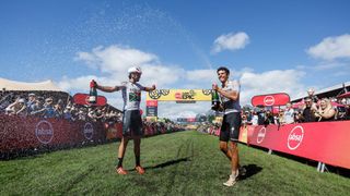 Matt Beers and Christopher Blevins celebrate with champagne on the finish line of Cape Epic 2023