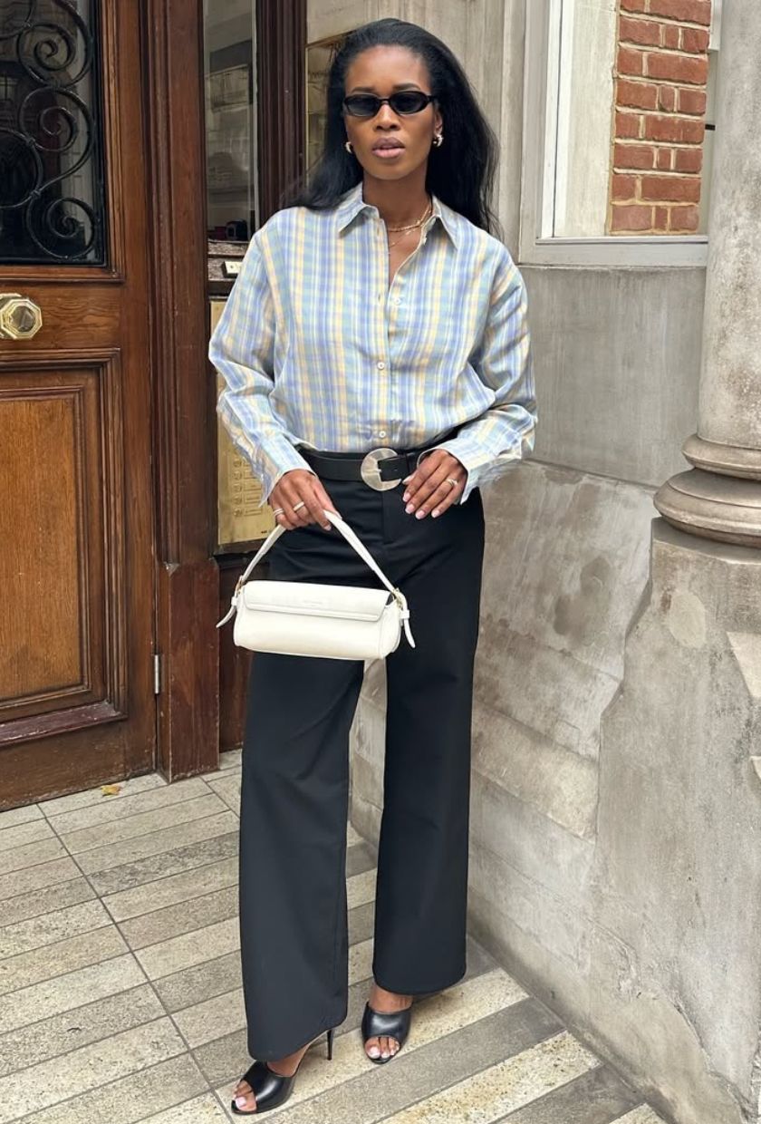 @nlmarilyn wears a check shirt, indigo jeans, black mules and a white leather bag