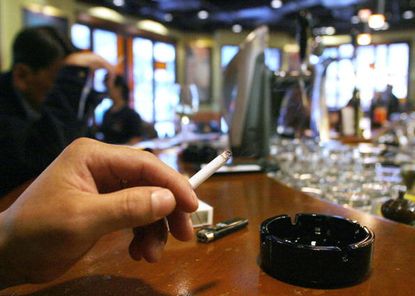 A person smokes in a pub.
