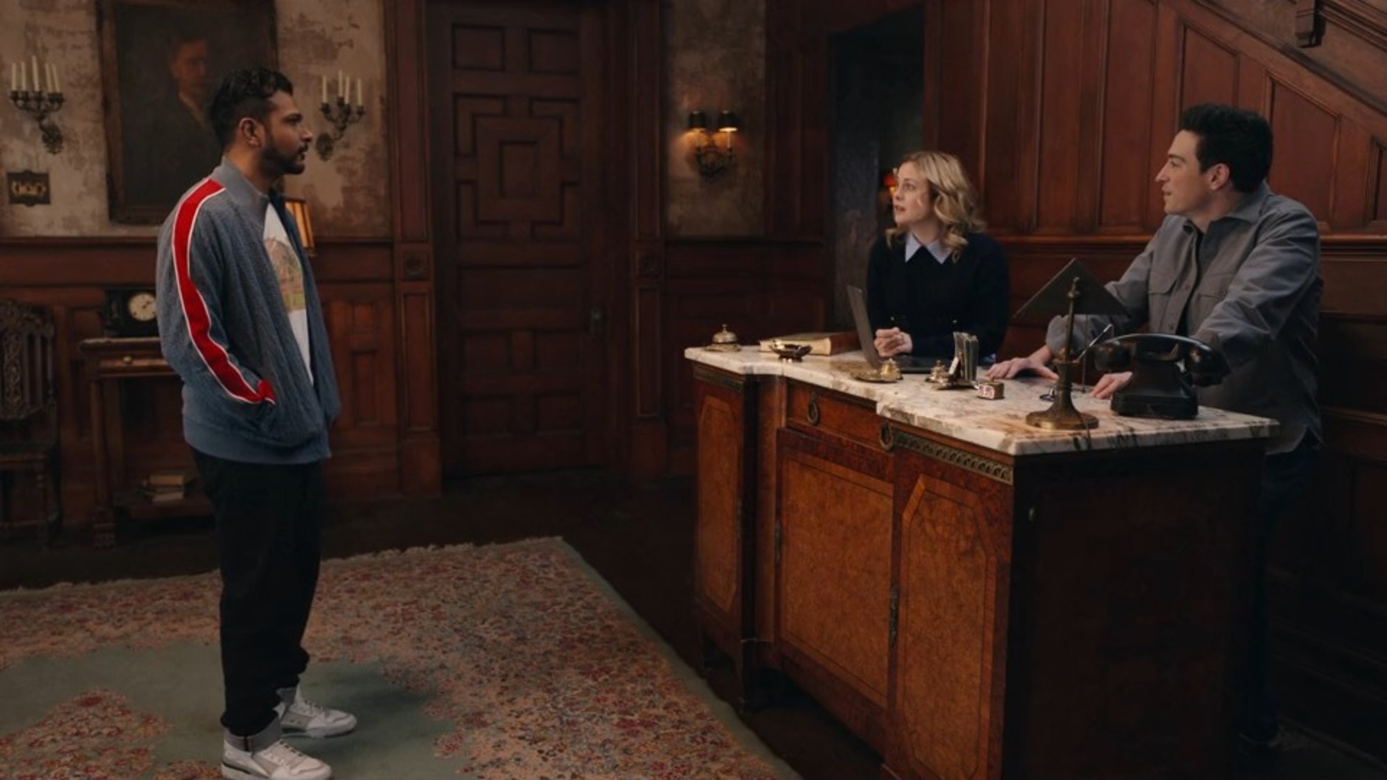 Utkarsh Ambudkar, Rose McIver, and Ben Feldman talking in Ghosts.