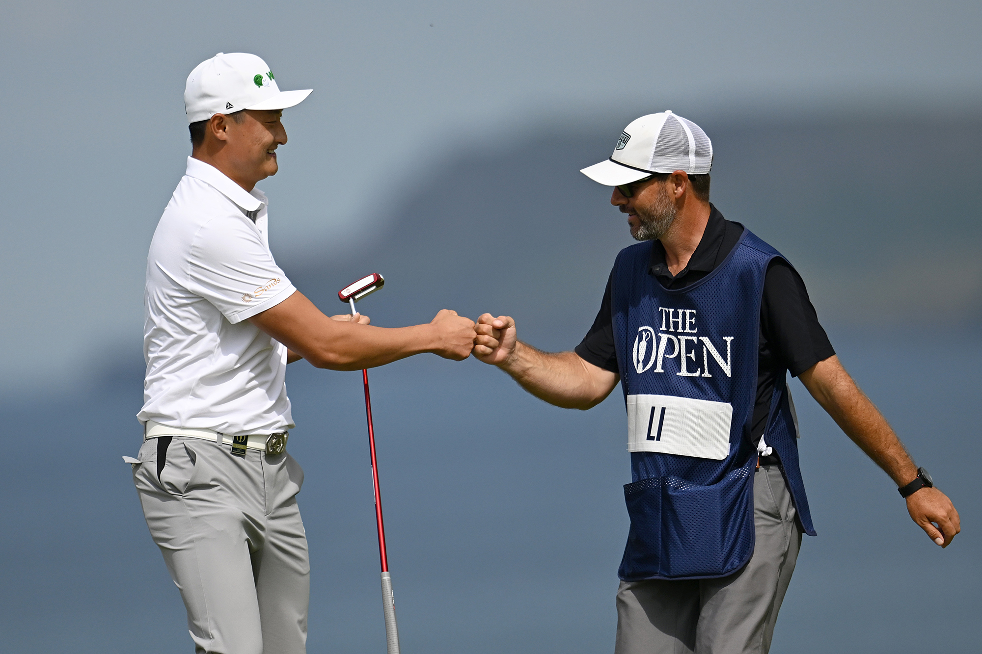 Haotong Li fist bumping his caddie at the Open Championship in 2025, where he finished fourth