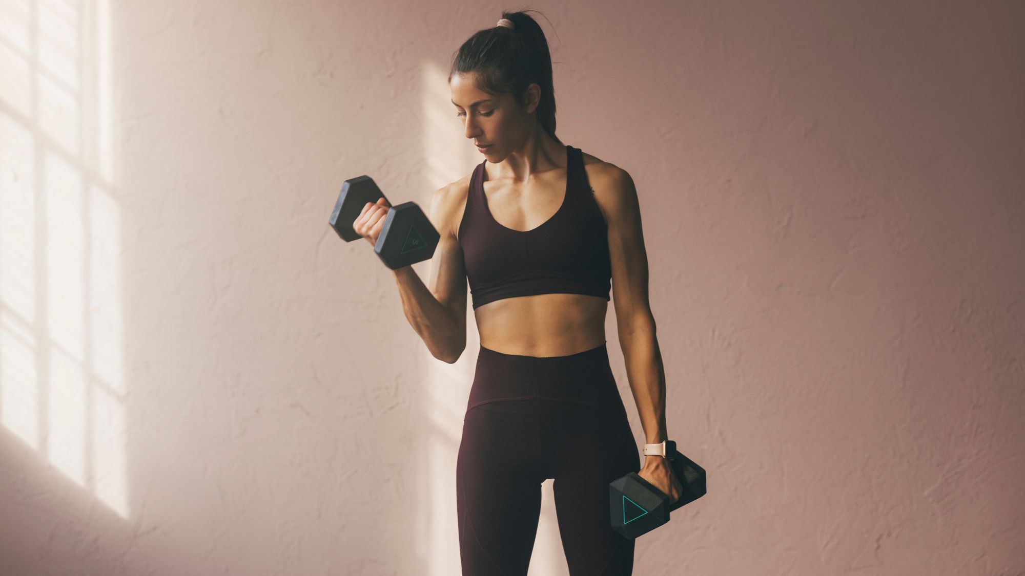 A woman using dumbbells in a studio