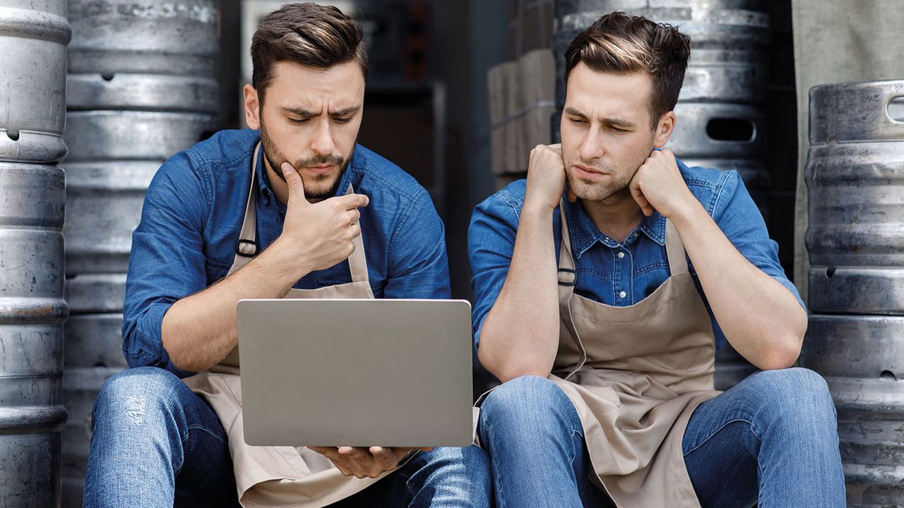 Smoulderingly hip young craft brewers stare moodily at a laptop