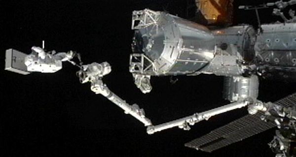 Flight Engineer Akihiko Hoshide rides on the station&#039;s robotic arm. 