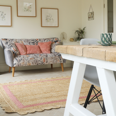 Rattan Scalloped rug in beige and pink in a neutral living room and floral sofa