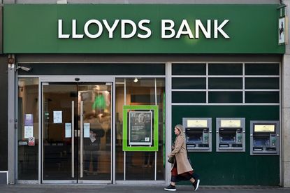 A pedestrian walks past a branch of a Lloyds Bank, in central London