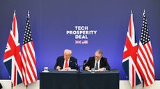 A photograph of US President Donald Trump, on the left, and UK prime minister Keir Starmer, on the right, signing the Tech Prosperity Deal. The pair are sat at a ceremonial table, flanked by UK and US flags. Behind them, a blue wall bears the white words 'TECH PROSPERITY DEAL', with the UK and US flags shown beneath.